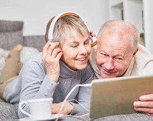 Header-Artikel: ein älteres Paar liegt auf dem Bett und schaut gemeinsam in ein Tablet