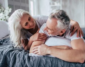 Header-Artikel: Seniorenpaar in Bett kuschelt miteinander.