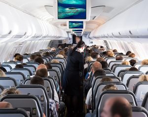 Header-Artikel: Innenansicht von Passagieren und Kabinenpersonal in einem Flugzeug