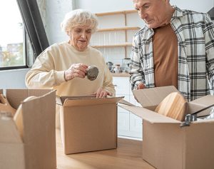 Rentnerpaar zieht in ein neues Zuhause und packt Kisten ein.