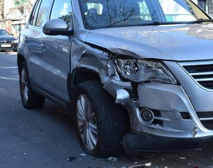 Ein Auto mit einem Blechschaden am rechten vorderen Scheinwerfer.
