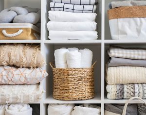 Ein Regal mit ordentlich zusammengelegten Decken und Handtüchern.
