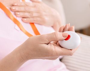 Großaufnahme einer Hand die einen Notfallknopf hält.